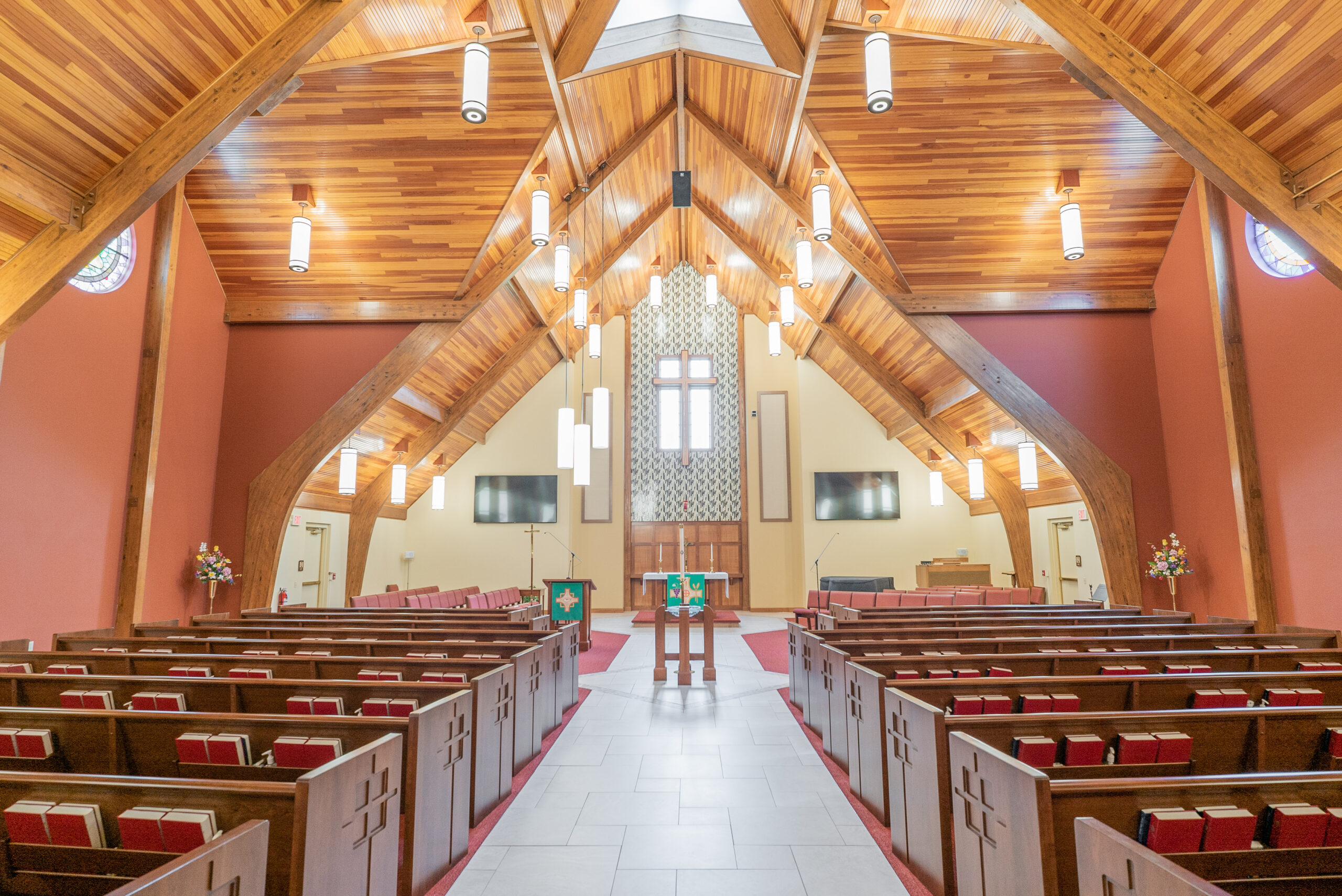 Inside Of A Church With Red Seats And Wooden Ceilings.