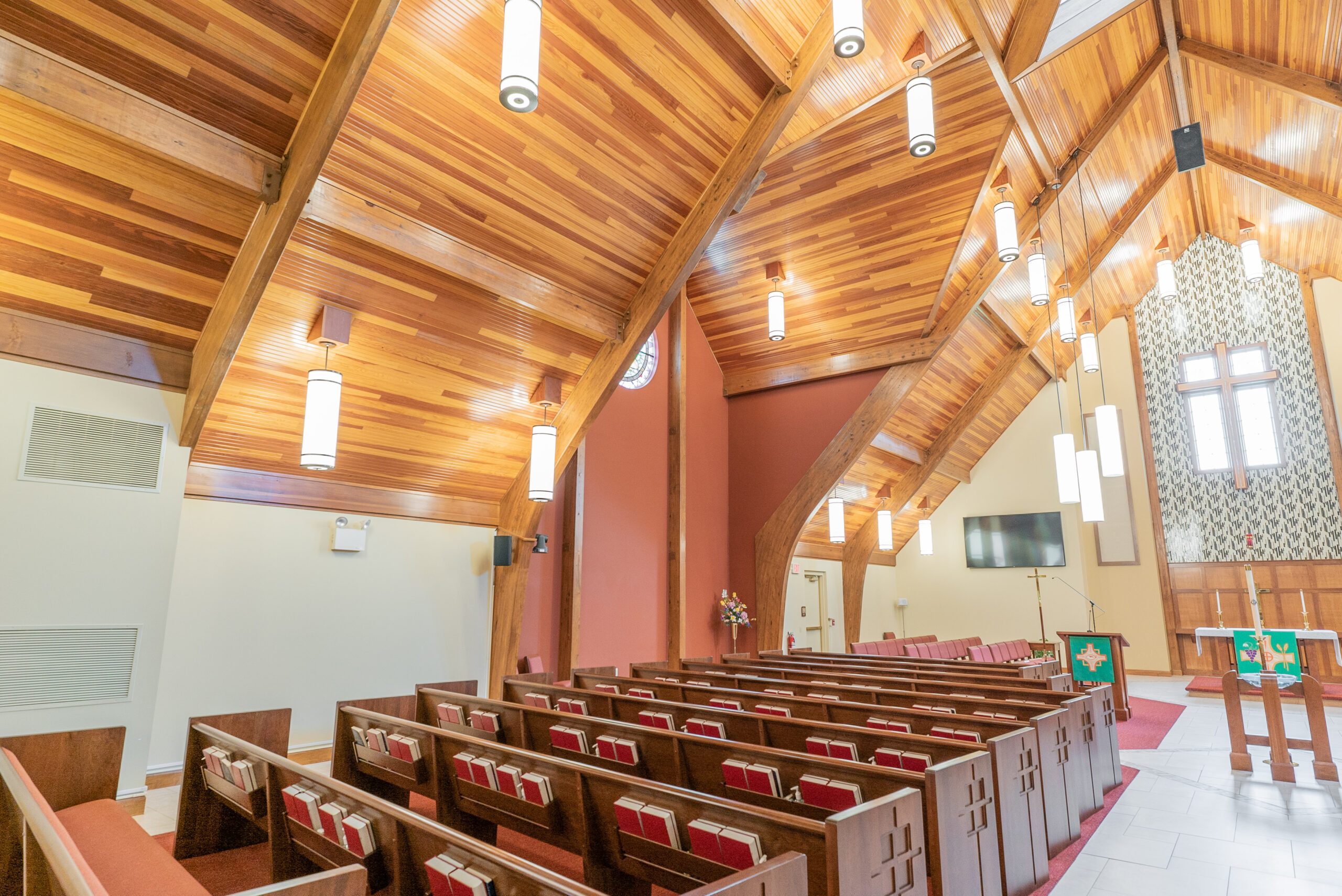 Inside Of A Church With Red Seats And Wooden Ceilings.