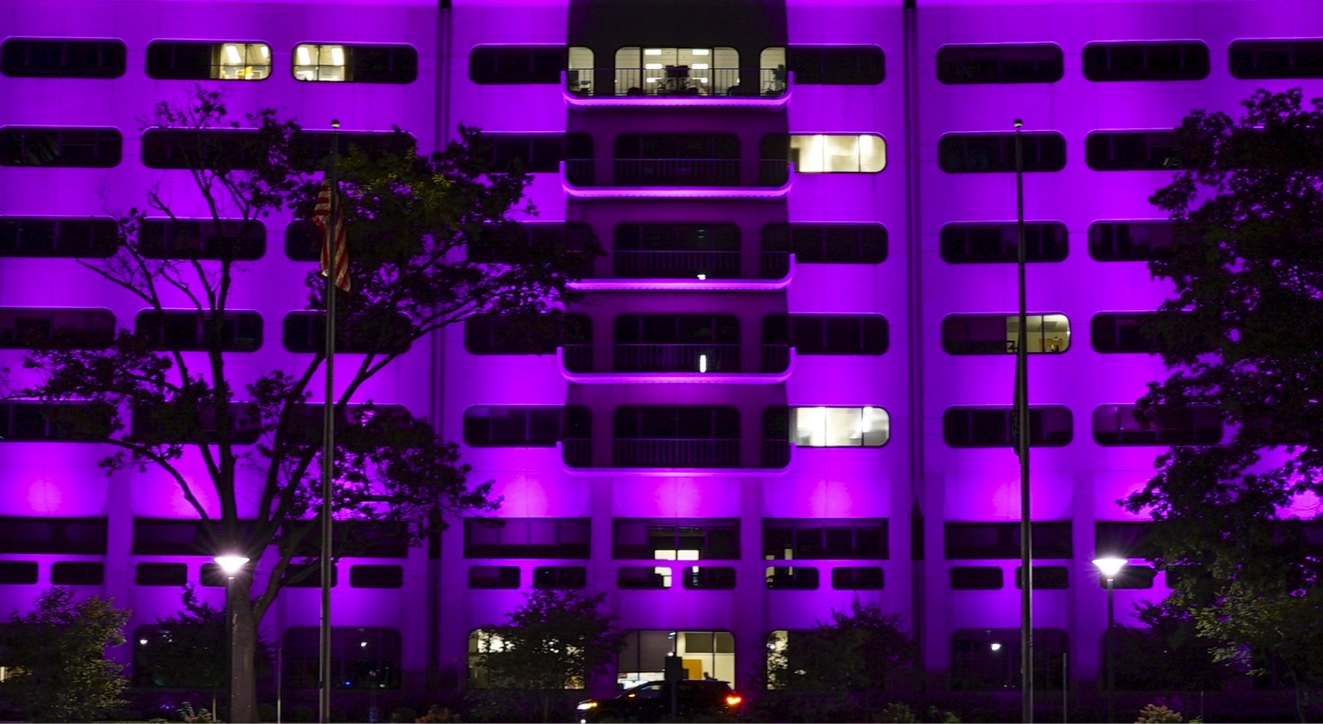 The Outside Of A White Building Lit Up With A Purple Light.