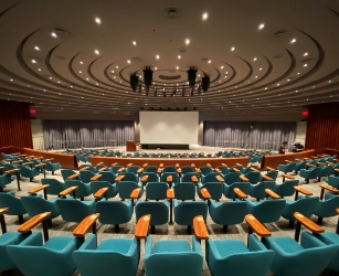 A Large Empty Auditorium With Blue Seat.